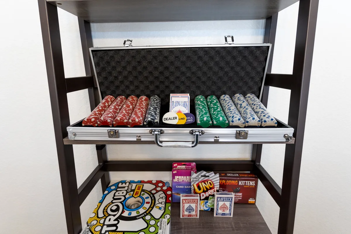 A playful close-up of a coffee table filled with board games, poker chips, and game boxes, suggesting an inviting atmosphere for family fun and interactive evenings.
