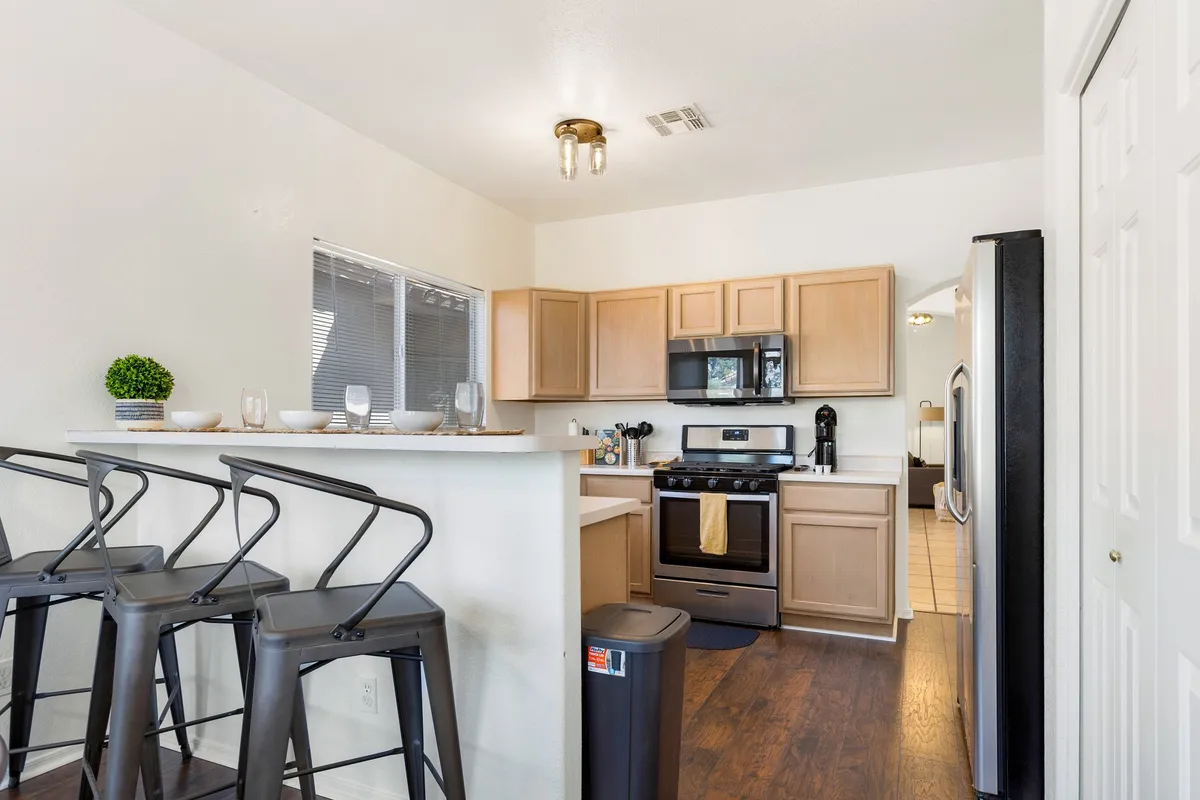 A stylish kitchen island with stainless steel appliances and bar stools ready for casual breakfasts or impromptu snack breaks. The setup encourages interaction, with plenty of space for cooking, entertaining, and family time.